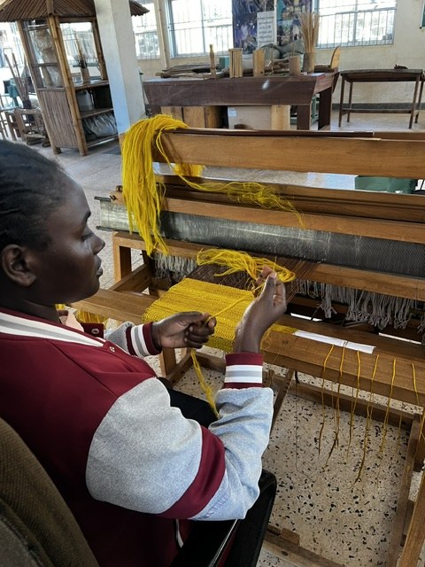 A trainee weaving fibre yarn on a handloom